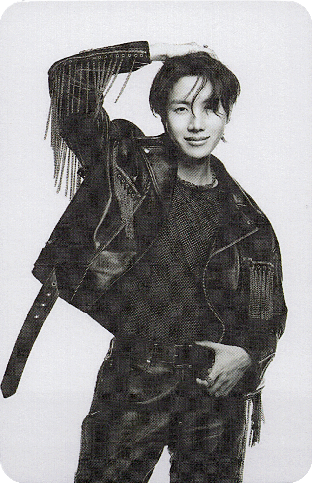BTS member J-Hope wearing a leather jacket with fringe details on a white background