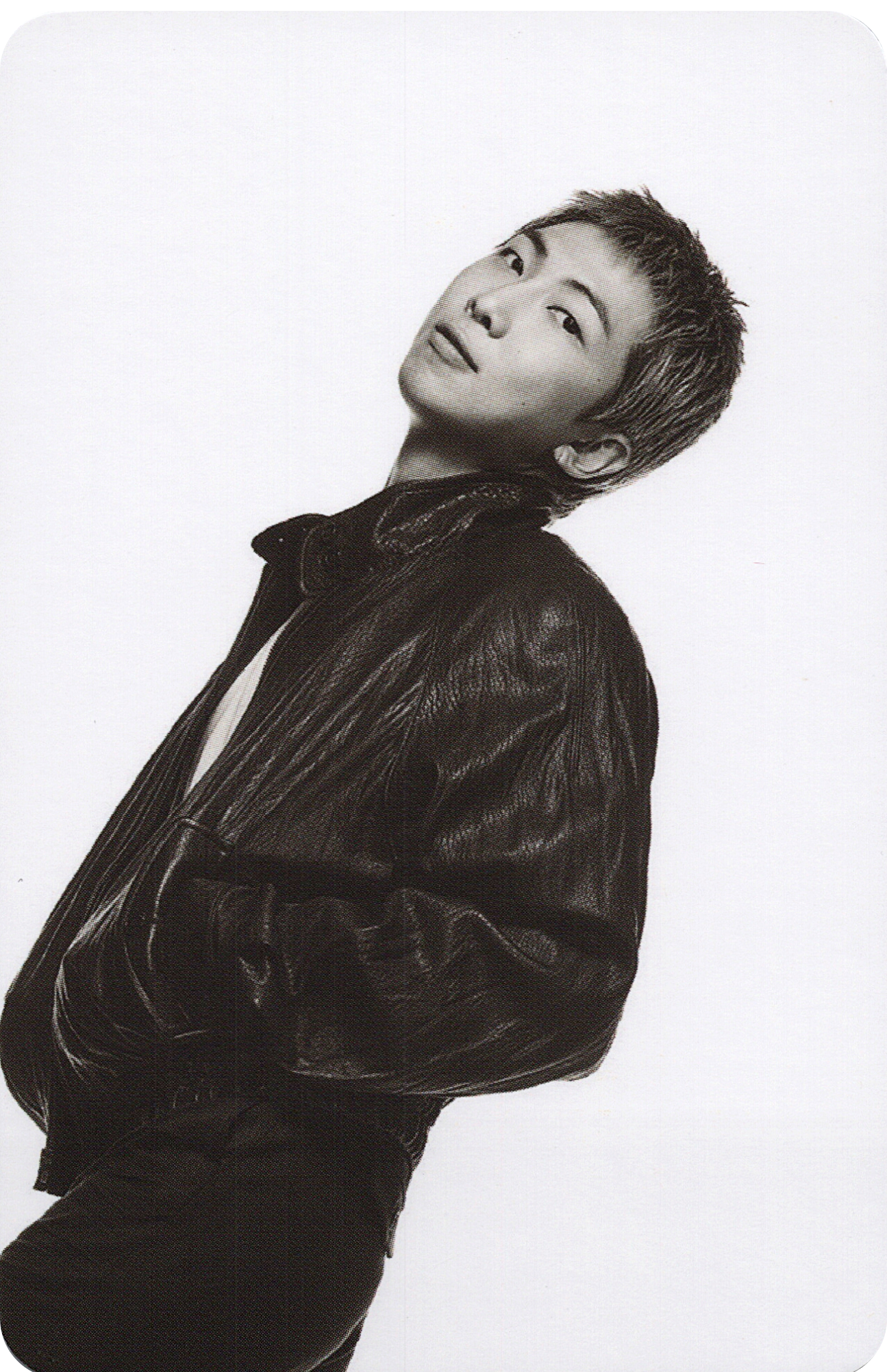 BTS member RM wearing a shiny black jacket against a white background
