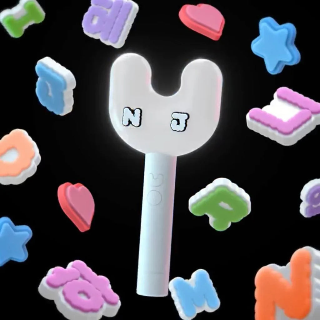 White k-pop girl group New Jeans lightstick toy on a black background with colorful letter-shaped object