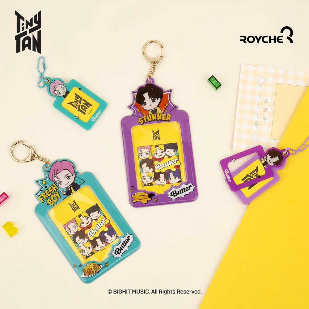 Two keychains with cartoon characters on a beige background, featuring Tiny Tan and Royche logos.