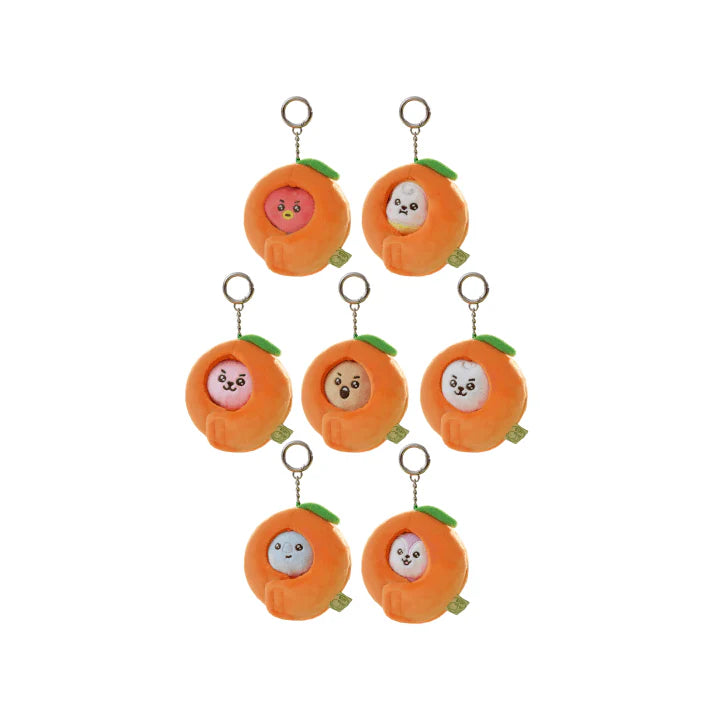 Set of BTS BT21 plush keychains shaped like cartoon characters inside orange peels on a white background