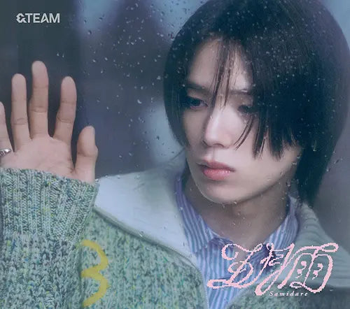 &Team member K wearing a green sweater with a hand touching a glass surface for Samidare album CD